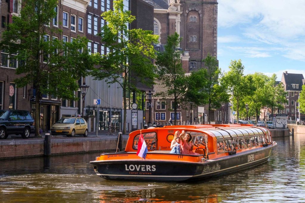 Туристы в круизе по каналам Амстердама