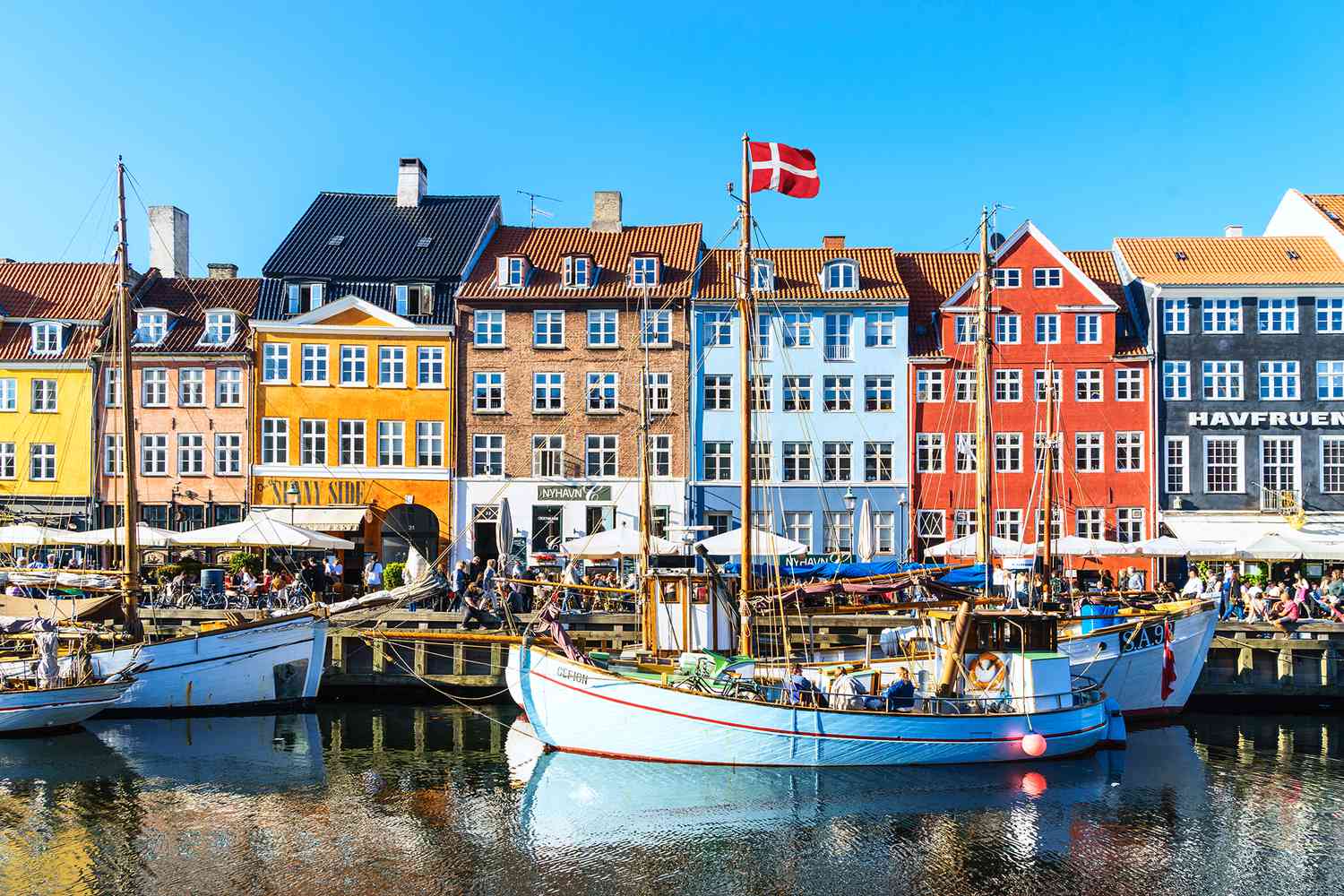 Панорамный вид на город и толпы, наслаждающиеся солнцем и ресторанами в Нюхавне, Копенгаген.